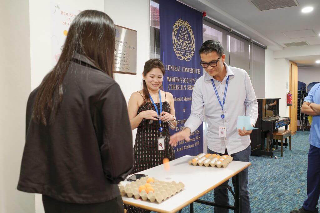 MWS CEO Calvin Ngo trying his hand at the Ponginator game, where players must bounce ping pong balls into the sockets of an egg carton