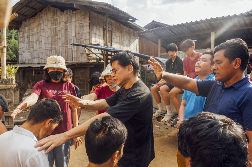Lyndon (in black) praying for villagers at Payakongdee, Thailand