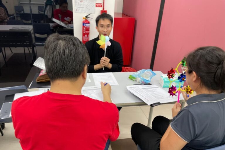 MWS social worker Titus using a pinwheel to help participants identify sensations in their cheeks and build body awareness