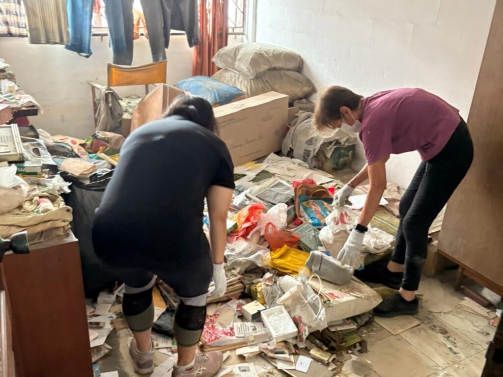 Volunteers clearing years of accumulated belongings from Kim Yam’s flat