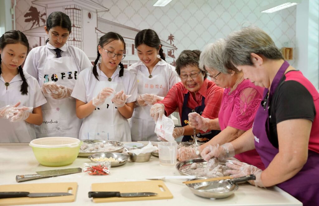 An intergenerational cooking session involving seniors from MWS Wesley Active Ageing Centre – Jalan Berseh and MGS students (Photo Credit: Methodist Girls' School)